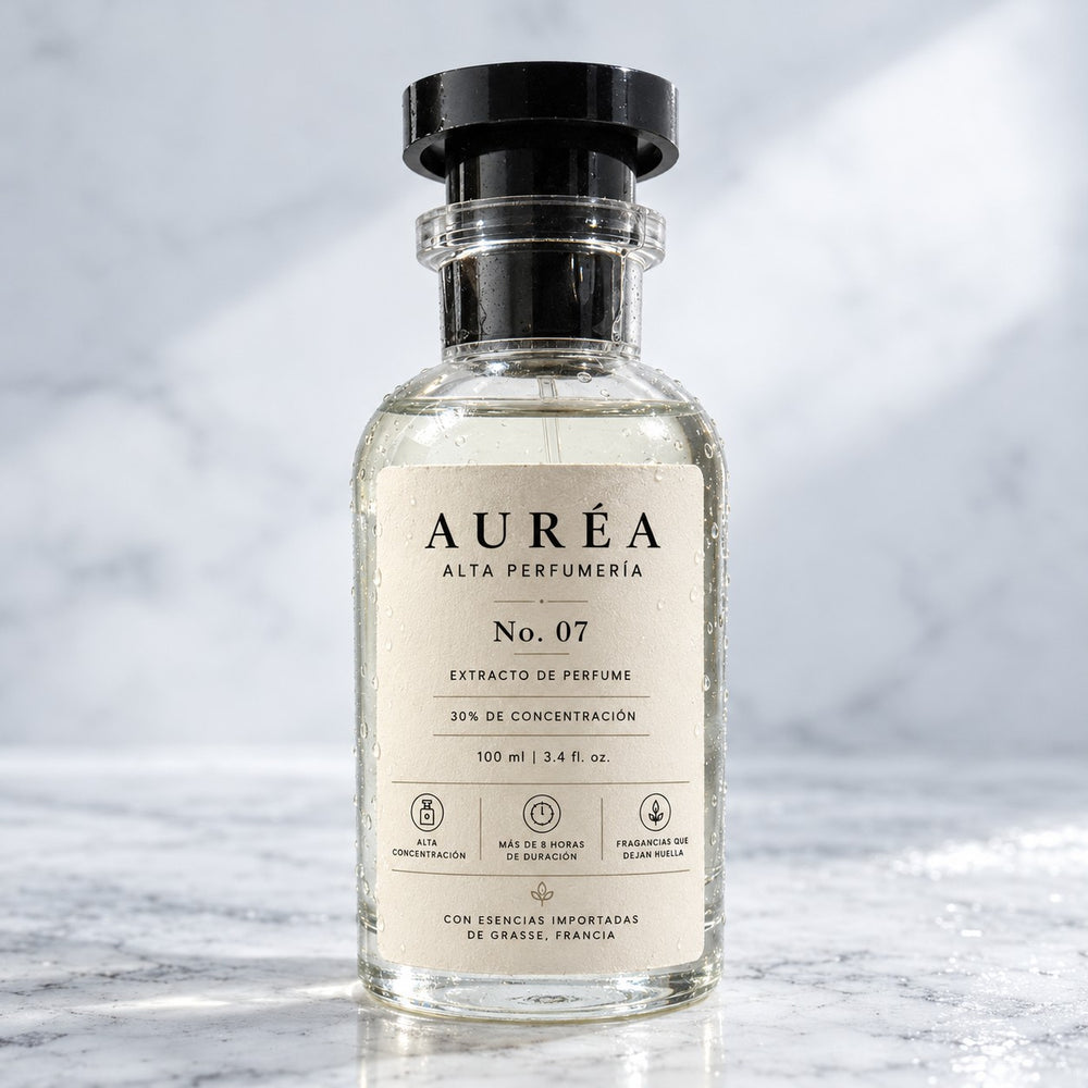 Frasco de perfume Auréa con gotas de agua sobre piedra clara y fondo luminoso.